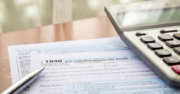 Tax form 1040, a pen and a calculator © vinnstock/Shutterstock.com