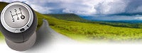green mountains and blue sky with a silver gear shift in the foreground