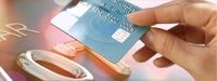 Credit card guide: Woman's hand holding blue credit card on peach background