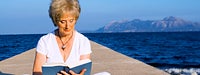 Retirement Guide: Senior woman sitting on dock, reading a book