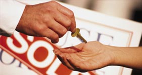 Real estate agent handing off house keys to homebuyer