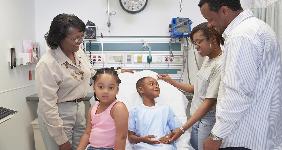 Family visiting young boy in hospital | ERproductions Ltd/Getty Images