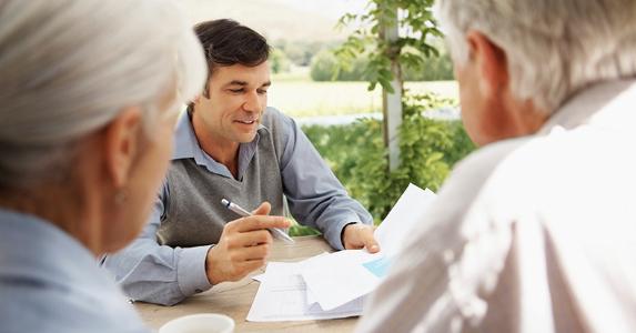 Adult son showing paperwork to elderly parents