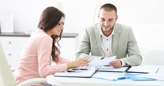 FSBO seller gets hit with buyer's agent commission Agent and client going over paperwork in office © Africa Studio/Shutterstock.com
