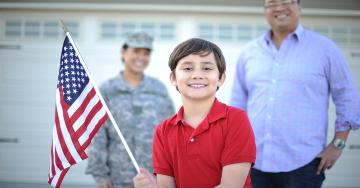 Boy holding the American flag | Veterans United