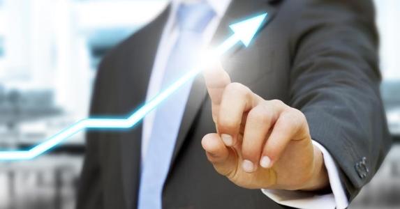 Businessman touching a rising investing arrow © sdecoret/Shutterstock.com