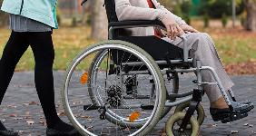Caretaker and woman patient on wheelchair outdoors © Photographee.eu/Shutterstock.com