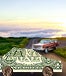 A car made out of money in the forefront with another red car in the back on a country road with the sunset
