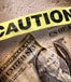 A ripped dollar bill and a yellow tape reading "CAUTION" 