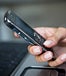 Cell phone in woman's hand in front of computer