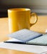 A desk with coffee and a check book