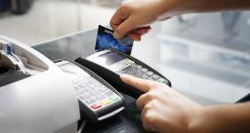 Close-up woman swiping debit card in terminal
