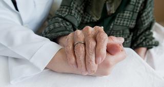 Doctor and elderly woman holding hands © sezer66/Shutterstock.com