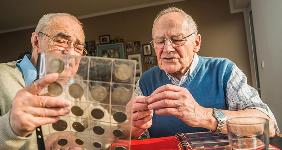 Coin collectors examining coins | Westend61/Getty Images