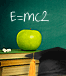 Stack of books, green apple, graduation hat and an equation written on the board