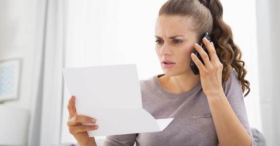 Why is debt collector bothering my peeps? Concerned woman on phone © Alliance/Shutterstock.com