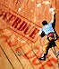 A guy in a blue shirt and khaki pants rock climbing with "Overdue"(in black) and "Past Due"(in red) written on the rock