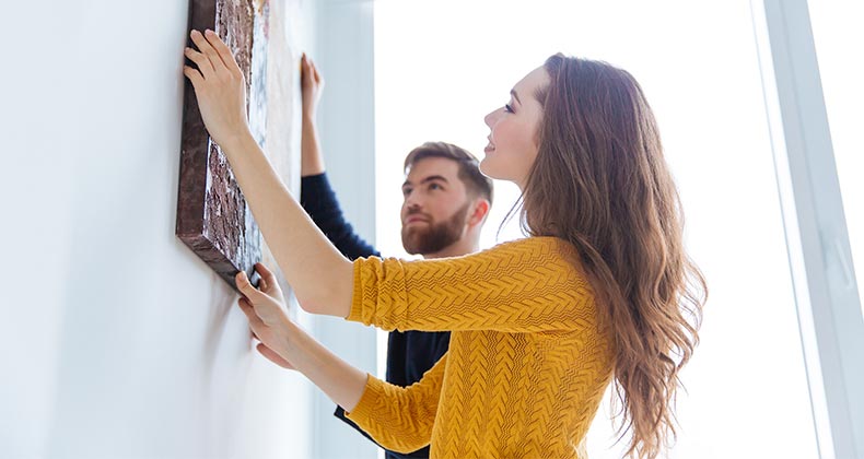 Find your jumbo, FHA loan limits Couple hanging art on wall | ESB Professional/Shutterstock.com