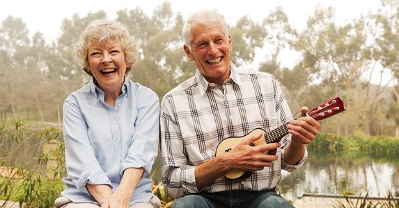 Couple laughing while playing ukelele | David Jakle/Getty Images