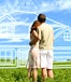 Couple standing in a field looking at their dream house drawn in the clouds