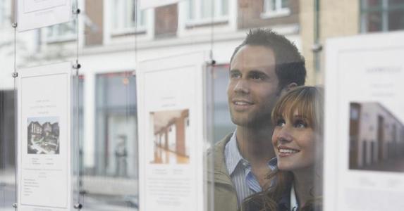 Deciding between ARM and fixed-rate mortgages Couple looking at real estate listing in window | bikeriderlondon/Shutterstock.com