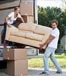 Couple moving a loveseat