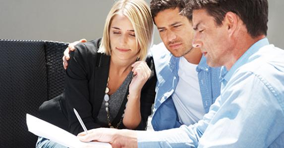 Couple reading paperwork with adviser © Fotolia.com