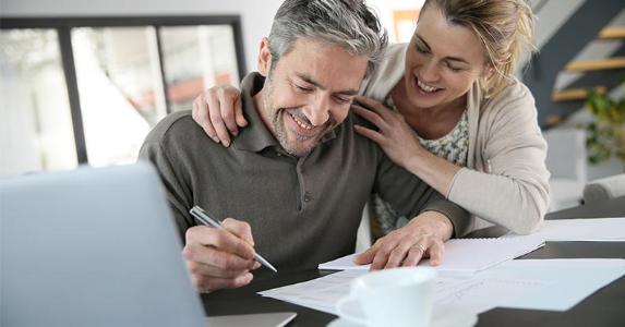 How to e-file your tax return Couple signing paperwork at home | goodluz/Shutterstock.com