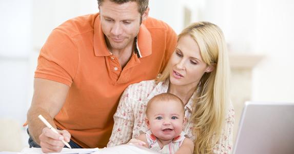 Couple with a baby on lap, working on paperwork © Monkey Business - Fotolia.com