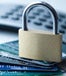 Small lock sitting on a stack of blue-tinted credit cards