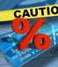 Credit card with "Caution" and a % sign pointing down