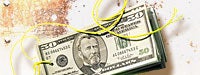 A stack of 50 dollar bills with a yellow string going through it and a dirty white background
