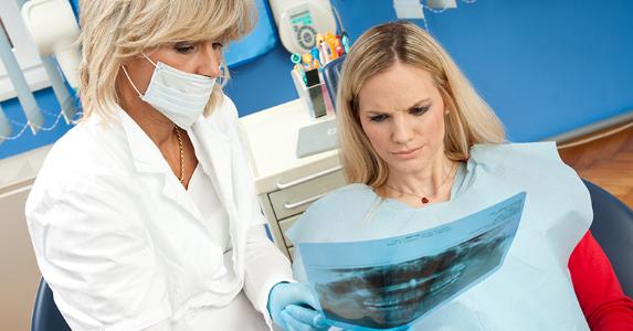 Dentist showing dental x-ray to patient © dean bertoncelj/Shutterstock.com