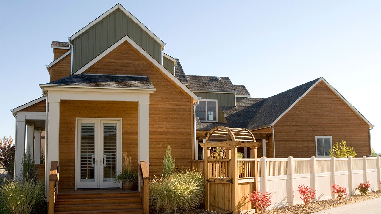 How to tell an APR from a mortgage rate Modern wood-paneled house on sunny day | Sarah-Jane Joel/Getty Images