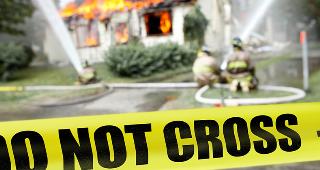 Firefighters at house fire, yellow tape © Frenzel/Shutterstock.com