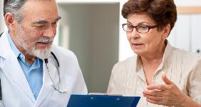 Doctor going over medical chart with patient © Alexander Raths/Shutterstock.com