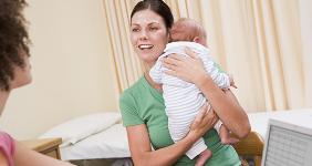 Doctor using a laptop with a woman holding a baby © Monkey Business Images/Shutterstock.com