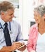 doctor with elderly woman patient clipboard