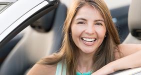 Smiling woman in convertible © Andresr/Shutterstock.com