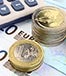 Euro bills coins and calculator pen