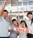 family holding sold sign