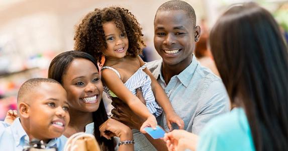 Girl holding out card to cashier © Andresr/Shutterstock.com