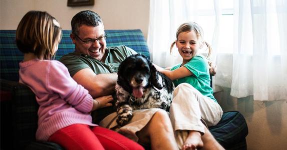 Father and kids playing with dog | MoMo Productions/Getty Images