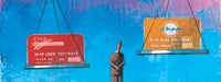 A cartoon man in a suit looking at an uneven scale with a red credit card on the left scale and a yellow credit card on the right