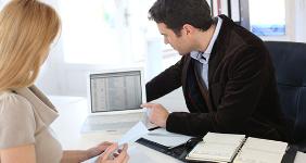 Financial adviser and woman looking at computer screen © Goodluz/Shutterstock.com