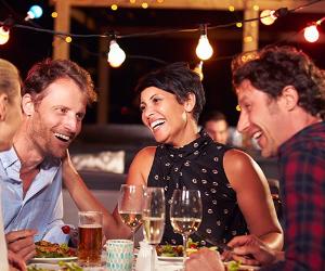 Friends laughing at dinner © MonkeyBusiness Images/Shutterstock.com