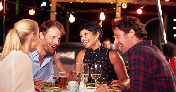 Friends laughing at dinner © MonkeyBusiness Images/Shutterstock.com