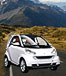small white car on road with mountains behind