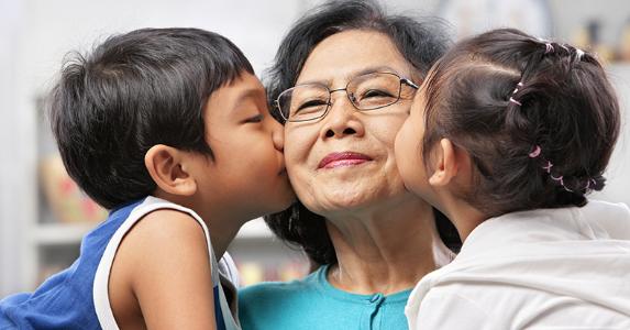 Grandmother getting kissed by grandchildren © iStock