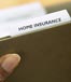 hand holding home insurance folder